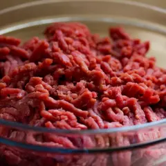 Mielone mięso wołowe w szklanej misce. Zastanawiasz się, jak pozbyć się specyficznego zapachu dojrzałej wołowiny przed gotowaniem?