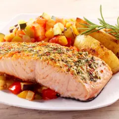 Pieczony łosoś z ziołami i czosnkiem, podany z pieczonymi ziemniakami i warzywami. Idealne przyprawy do ryby z piekarnika, które podkreślają jej delikatny smak.