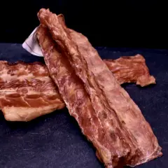 Surowe żeberka wieprzowe na ciemnym tle.