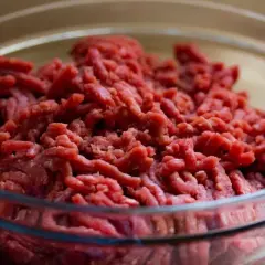 Surowa mielona wieprzowina w szklanej misce, gotowa do bezpiecznego rozmrażania wieprzowiny w mikrofalówce bez wstępnego ugotowania.