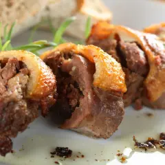 Faszerowana szyja gęsia, tradycyjny przepis babci na zapomniany rarytas z drobiu. Aromatyczne mięso z chrupiącą skórką, podane z pieczywem i rozmarynem.