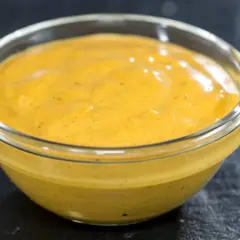 Gęsty, żółty sos curry na mleczku kokosowym w szklanej miseczce. Dlaczego sos się warzy i jak to naprawić?