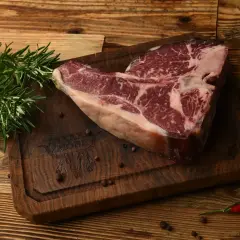 Surowy stek na desce z rozmarynem i pieprzem. Sezonowanie wołowiny na mokro vs na sucho kluczowe różnice w smaku.