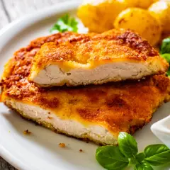 Chrupiący kotlet drobiowy, idealny sposób na to, jak odgrzać smażonego kotleta drobiowego żeby panierka znowu była chrupiąca. Podany z ziemniakami i sosem.
