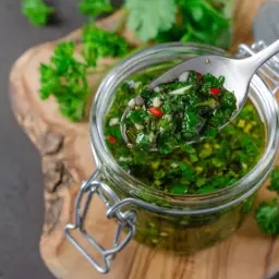 Jak zrobić autentyczną argentyńską marynatę chimichurri do wołowiny? Świeża, zielona marynata z pietruszki, czosnku i chili w słoiku.