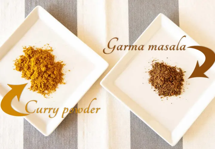 Na talerzykach: żółte curry powder i ciemniejsze garam masala. Poznaj różnice między tymi indyjskimi mieszankami przypraw.