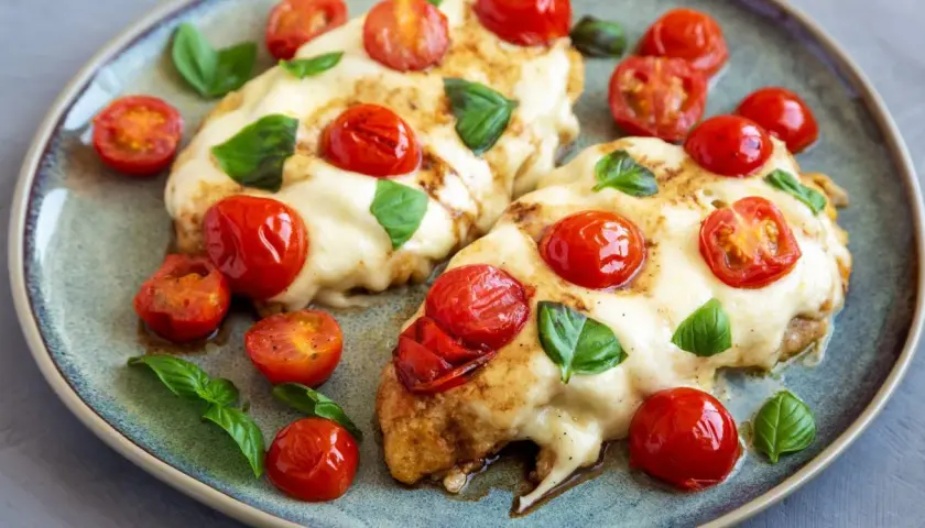 Kurczak caprese z mozzarellą i pomidorami – ekspresowe danie z jednej patelni. Pyszny, zapieczony kurczak z ciągnącym serem, pomidorkami i bazylią.