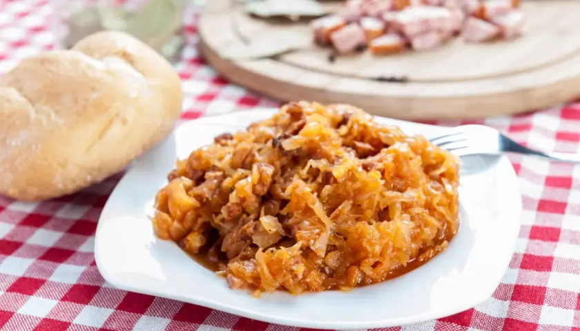 Pyszny bigos na talerzu. Przyprawy do bigosu krok po kroku w jakiej kolejności dodawać je do kapusty, by uzyskać idealny smak.