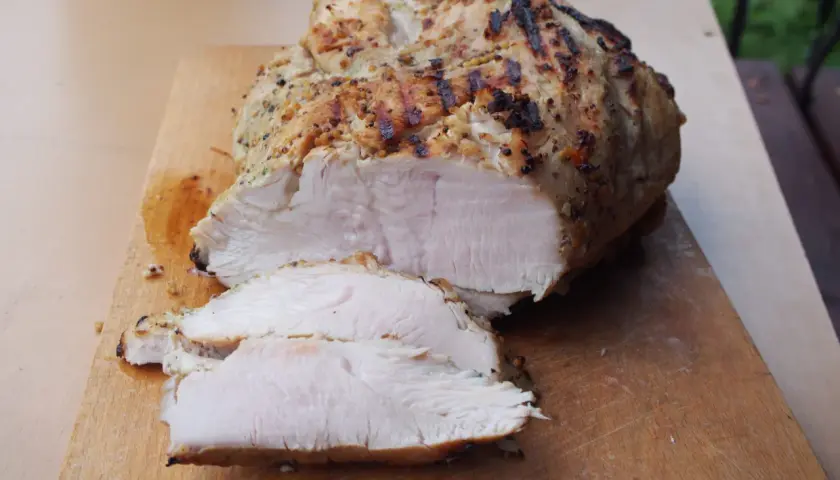 Idealnie krucha pierś z indyka sous vide, z przypieczoną skórką, pokrojona na desce. Dokładny czas i temperatura dla tej soczystości to sekret.