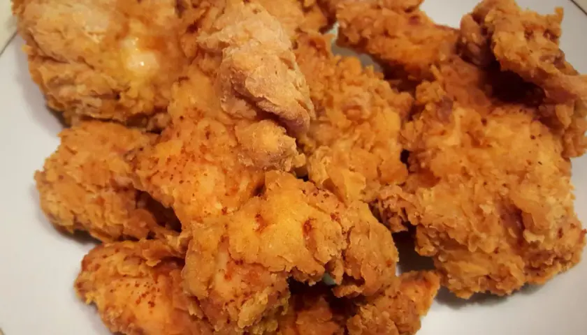 Chrupiące stripsy z kurczaka z airfryera bez kropli oleju, jak z KFC. Złociste i apetyczne kawałki kurczaka na talerzu.