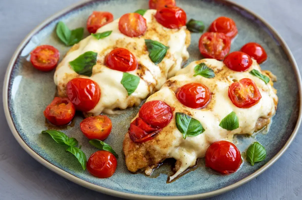 Kurczak caprese z mozzarellą i pomidorami – ekspresowe danie z jednej patelni. Pyszny, zapieczony kurczak z ciągnącym serem, pomidorkami i bazylią.