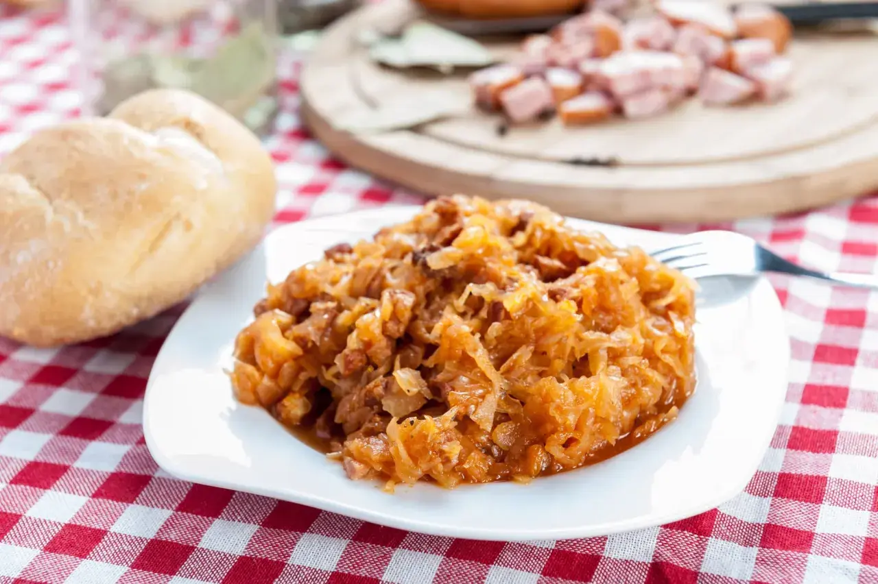 Pyszny bigos na talerzu. Przyprawy do bigosu krok po kroku w jakiej kolejności dodawać je do kapusty, by uzyskać idealny smak.