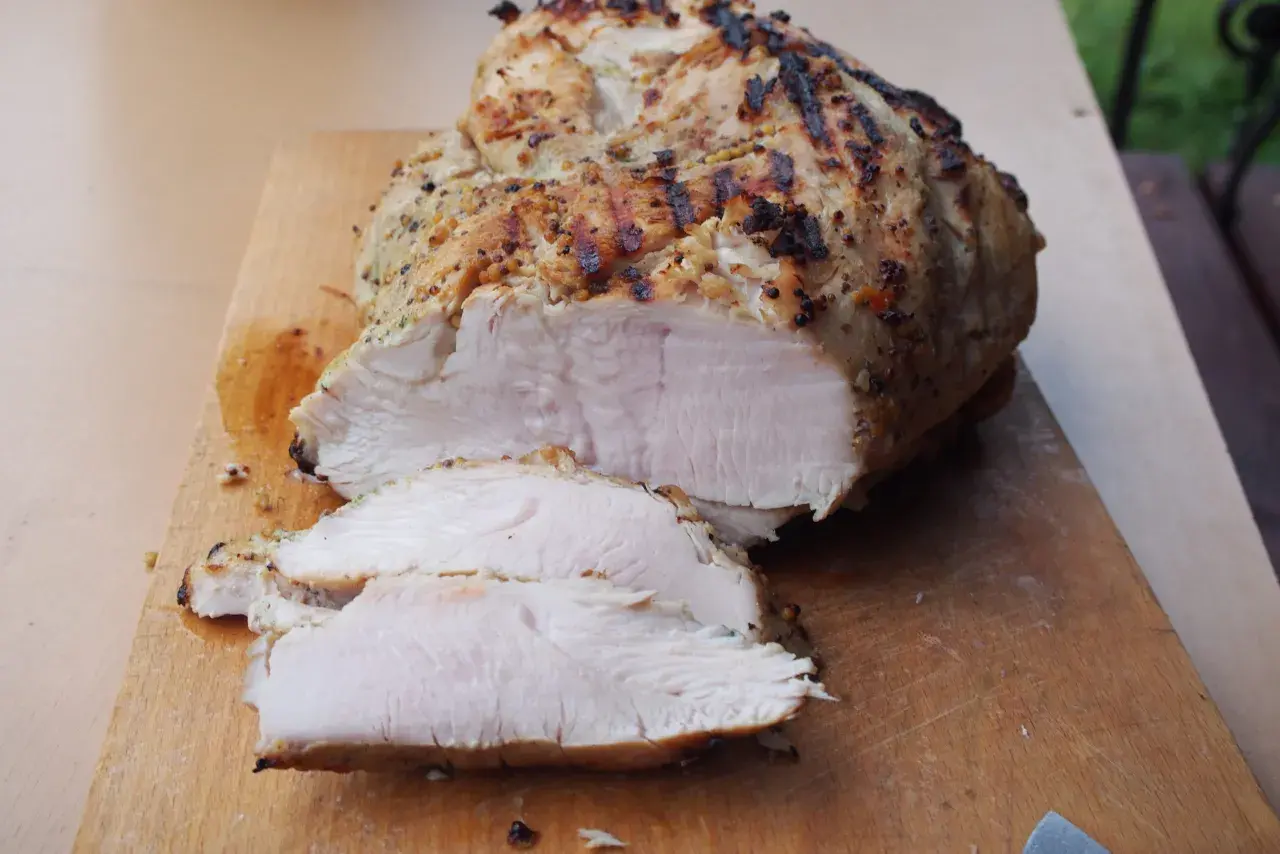Idealnie krucha pierś z indyka sous vide, z przypieczoną skórką, pokrojona na desce. Dokładny czas i temperatura dla tej soczystości to sekret.