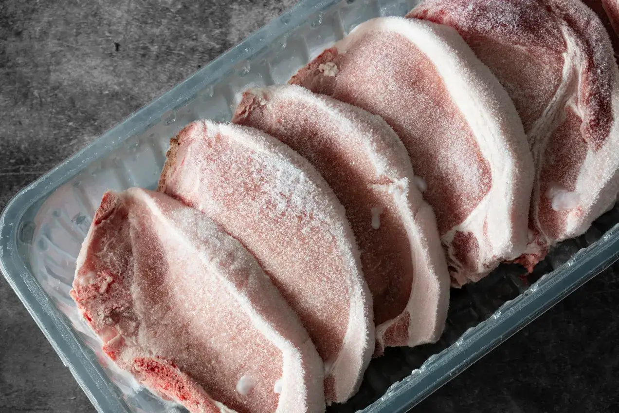 Zamrożone kotlety wieprzowe w plastikowym opakowaniu. Szybkie i bezpieczne rozmrażanie wieprzowiny w mikrofalówce bez wstępnego gotowania jest możliwe.