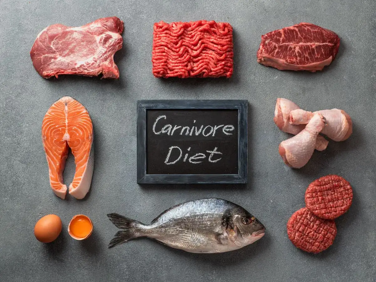 Dieta carnivore: efekty jedzenia samej wołowiny przez miesiąc? Na zdjęciu różne rodzaje mięsa, ryba, jajka i tabliczka z napisem 