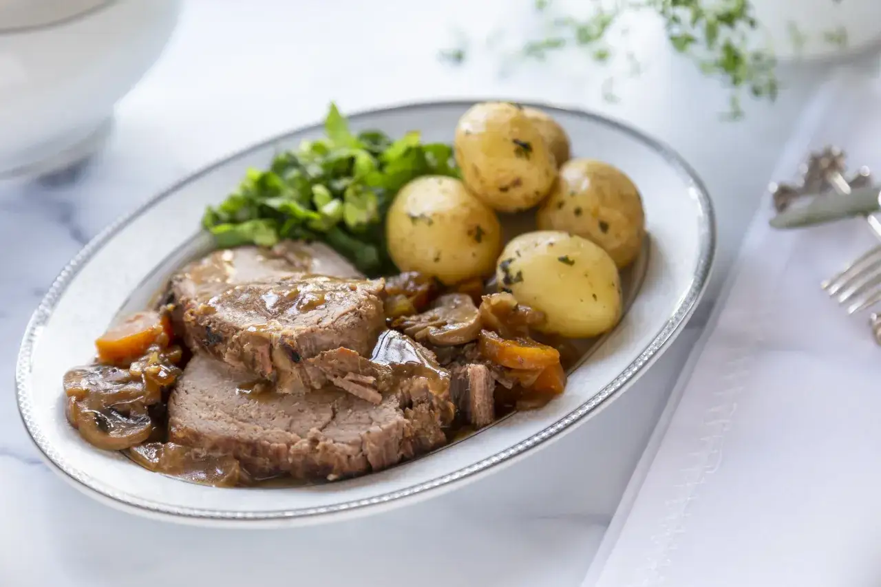 Pokrojona, soczysta pieczeń wołowa z warzywami i ziemniaczkami, idealna, gdy zastanawiasz się, jak uratować twardą pieczeń wołową z piekarnika.