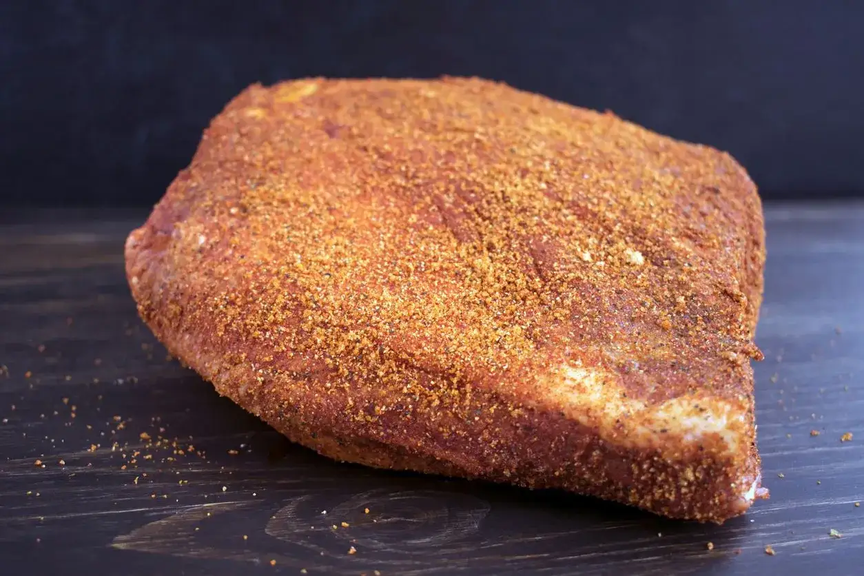 Gotowy do przygotowania pastrami z mostka wołowego we własnym domu? Ten kawałek mięsa, pokryty aromatyczną przyprawą, czeka na dalszą obróbkę.
