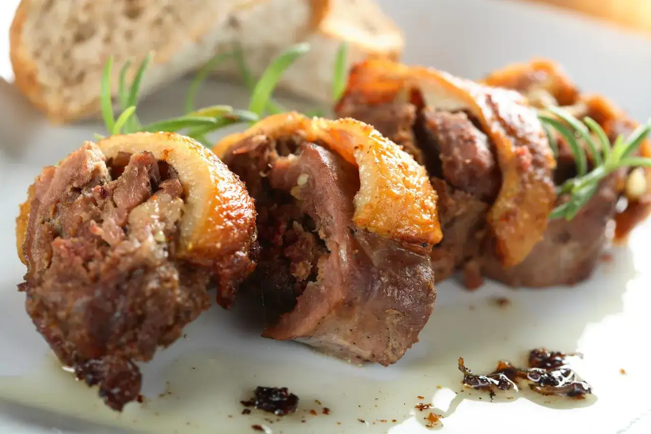 Faszerowana szyja gęsia, tradycyjny przepis babci na zapomniany rarytas z drobiu. Aromatyczne mięso z chrupiącą skórką, podane z pieczywem i rozmarynem.