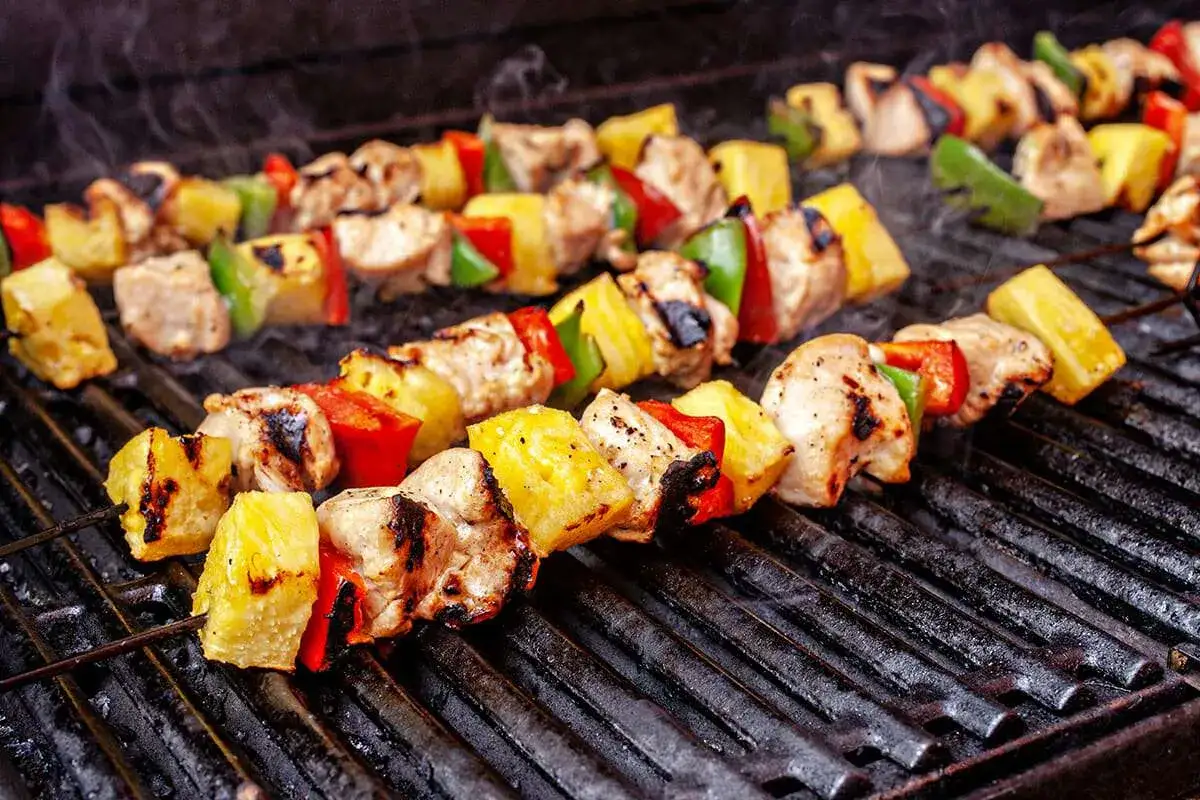 Dietetyczne szaszłyki drobiowe z ananasem na grillu. Jak zrobić, by owoc nie rozpadł się? Grillowane kawałki kurczaka, ananasa, papryki.
