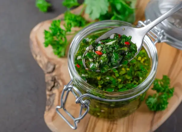 Jak zrobić autentyczną argentyńską marynatę chimichurri do wołowiny? Świeża, zielona marynata z pietruszki, czosnku i chili w słoiku.